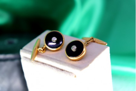 Botões de punho em ouro em formato oval com onix e zircónias no centro.